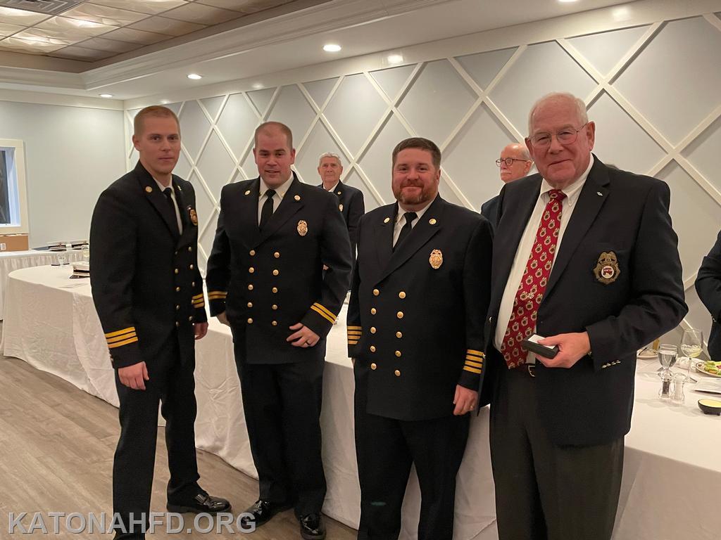 50 Year Member Ex Chief Hank Bergson with (from left) First Assistant Chief Matt Whalen, Second Assistant Chief John Whalen, and Chief Mike Griffiths. Photo by Erich Braun