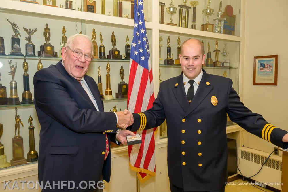Ex-Chief Hank Bergson accepting his daughter, Abigail’s 25 year badge on her behalf. Photo by Gabe Palacio.