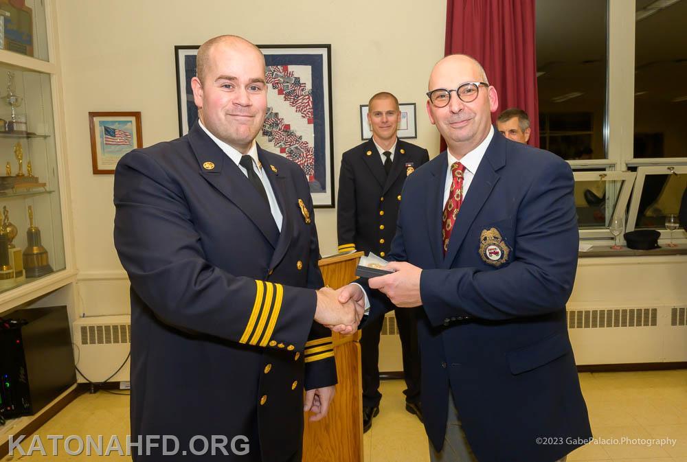 First Assistant Chief John Whalen presents a top responder award to Ex-Chief Bennett Schuberg. Photo by Gabe Palacio.